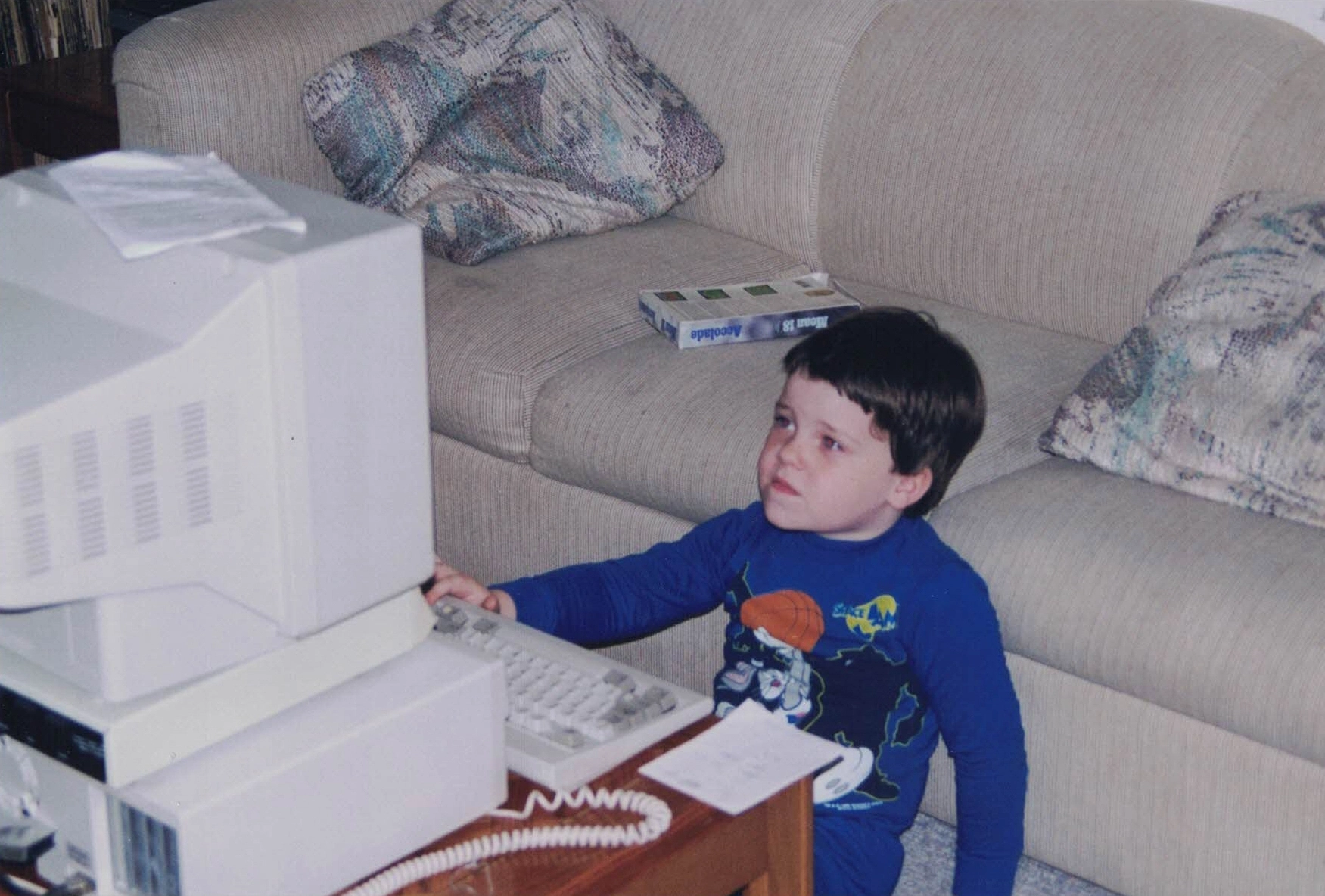 Mike Tarpey as a young boy in the mid-90s (sometime around kindergarten), using a PC for the first time while wearing a blue longsleeve Space Jam shirt.