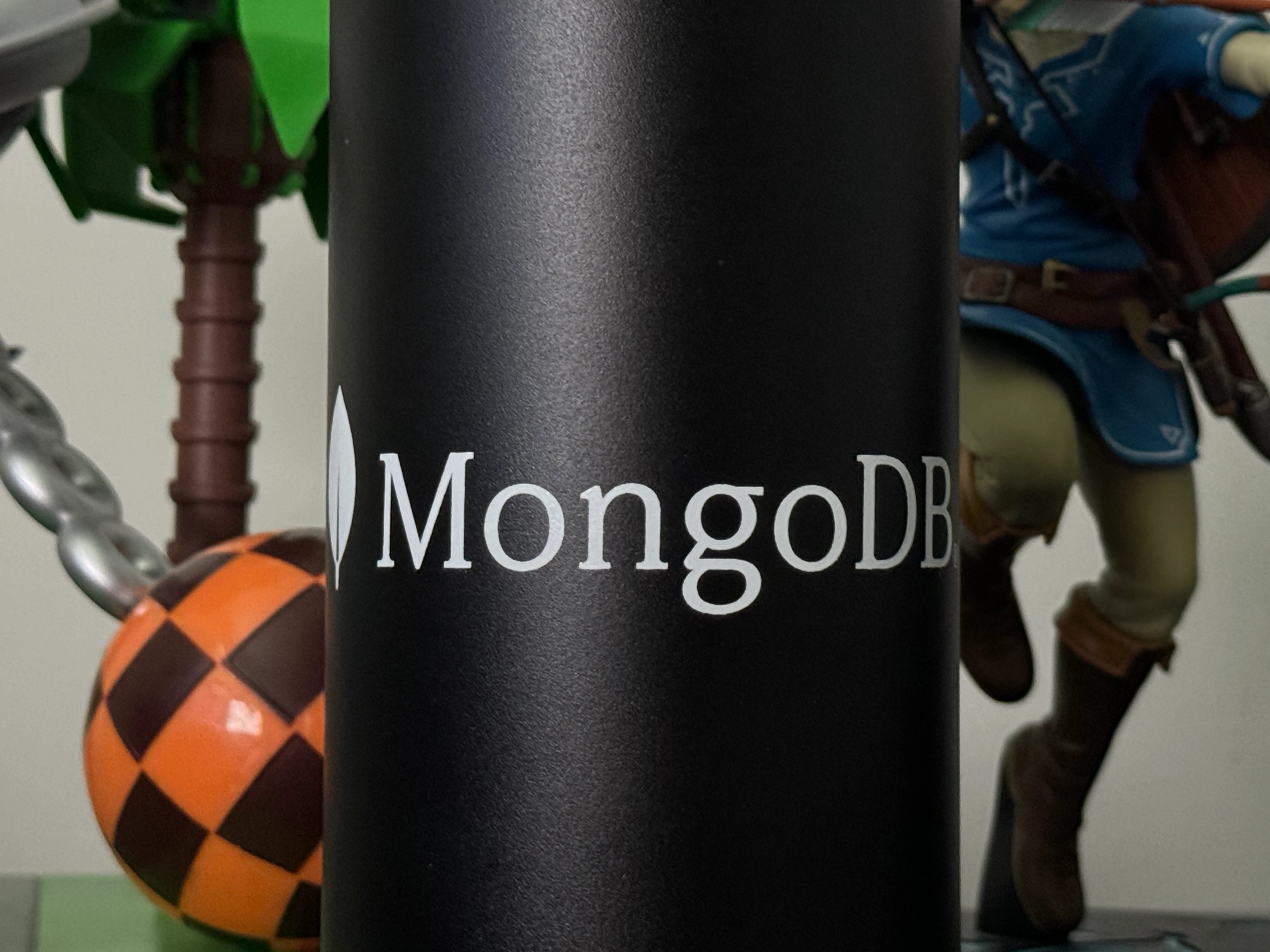 Zoomed-in shot of a MongoDB Camelbak water bottle, flanked on the left by a Dr. Robotnik figure and on the right by a Link figure from Breath of the Wild. Thanks to MongoDB for keeping me hydrated these days.